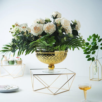 Elegant floral arrangement in a gold bowl with roses and greenery.