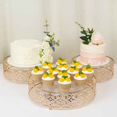 Elegant cakes and cupcakes displayed on decorative stands for a celebration.
