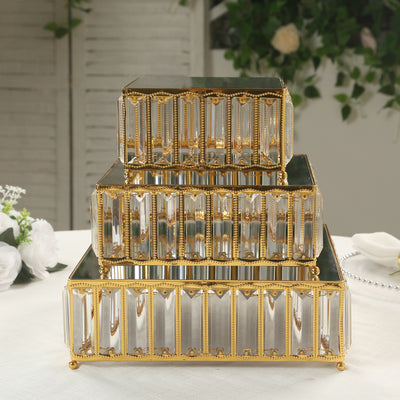 Decorative mirrored storage boxes with gold accents, stacked in three tiers.