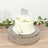 White floral cake with "Happy Birthday" topper on a decorative stand.