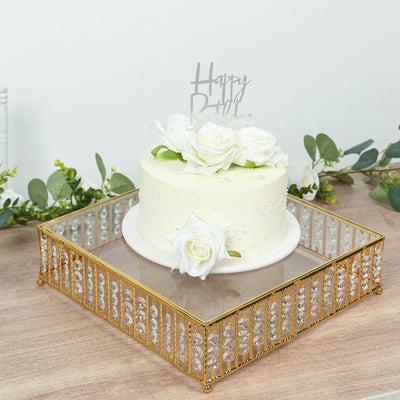 White birthday cake adorned with roses on a decorative mirror tray.