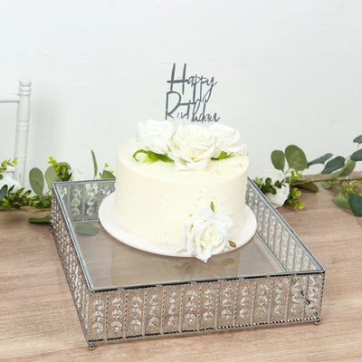 White cake with floral decoration and "Happy Birthday" topper on a decorative tray.