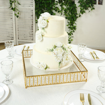 Elegant three-tier wedding cake adorned with white roses on a decorative mirror tray.