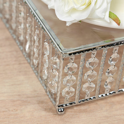 Decorative crystal box with floral arrangement on a wooden surface.