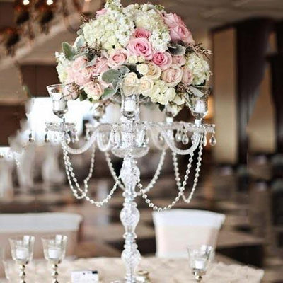 Elegant floral centerpiece with roses and hydrangeas on a crystal candelabrum.