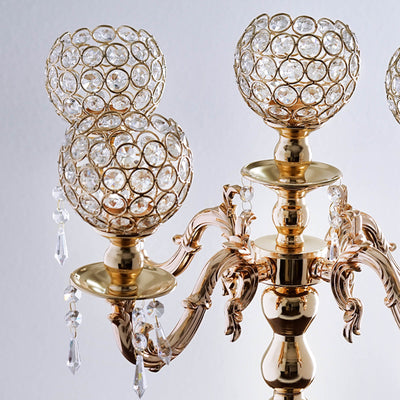 Elegant gold candelabra with crystal embellishments and decorative beads.