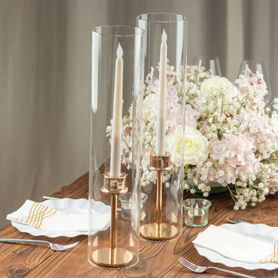 Elegant candle holders with white candles and floral centerpiece on a dining table.
