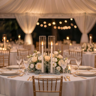 Elegant wedding reception table with candles, white roses, and gold table settings
