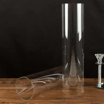 Two clear glass vases on a wooden surface.