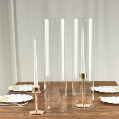 Elegant glass candle holders with gold accents on a wooden table.