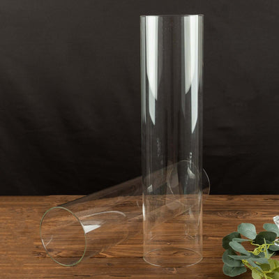 Two clear glass vases on a wooden surface.