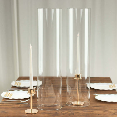 Clear glass candle holders with gold bases for elegant table decor.