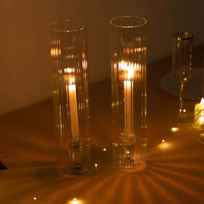 Elegant glass candle holders with lit candles, casting soft shadows.