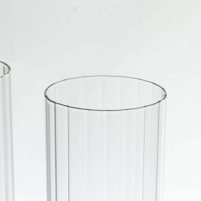 Clear ribbed glass tumblers on a white background