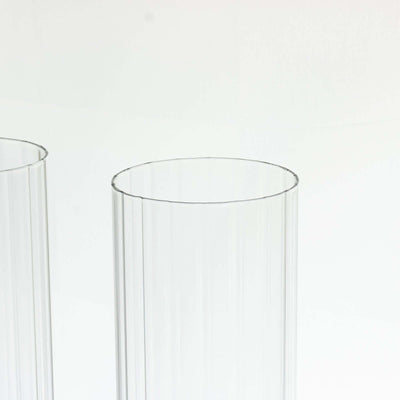 Clear ribbed glass vases on a plain background