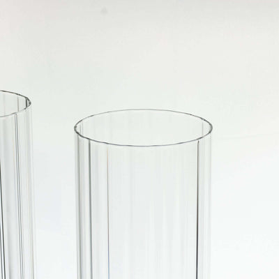 Clear ribbed glass vases on a plain background