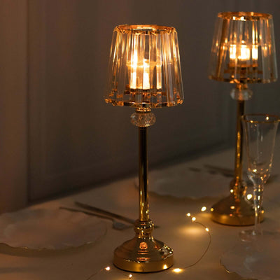 Elegant gold table lamp with clear shade and candlelight ambiance.