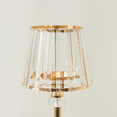 Elegant crystal table lamp with a golden accent shade.