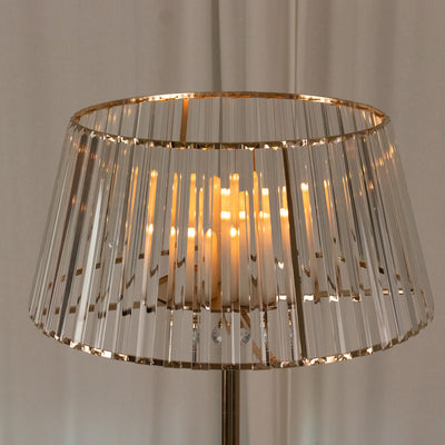Crystal table lamp with gold accents and warm glowing candles.