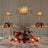 Elegant table setting with a floral centerpiece and candle lamp.