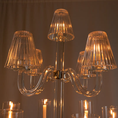 Elegant glass chandelier with illuminated shades and a sleek design.