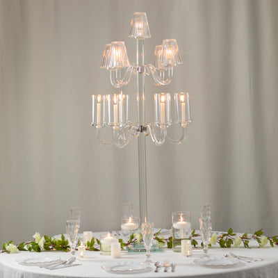 Elegant crystal chandelier with candles on a beautifully set dining table.