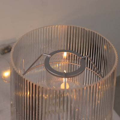 Transparent ribbed glass candle holder with metal ring detail.