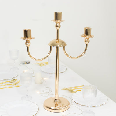 Gold candelabra with three candle holders on a dining table