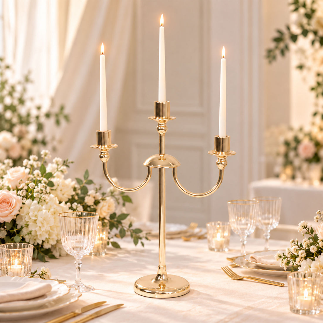 Gold three-arm candle holder centerpiece with lit candles at elegant wedding table
