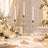 Gold three-arm candle holder centerpiece with lit candles at elegant wedding table