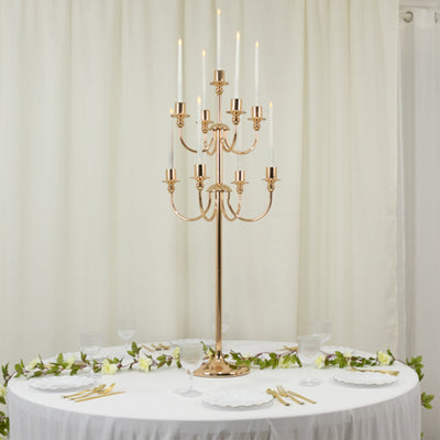 Elegant gold candelabra centerpiece with candles on a decorated table.