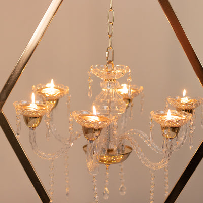 Elegant crystal chandelier with lit candles and intricate design.