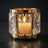 Luxury gold candle holder with faceted crystal panels and lit candle
