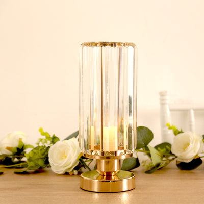 Elegant glass lamp with gold base and candle, surrounded by decorative flowers.