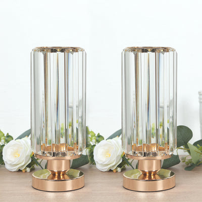 Pair of elegant crystal lamps with gold bases on a wooden surface.