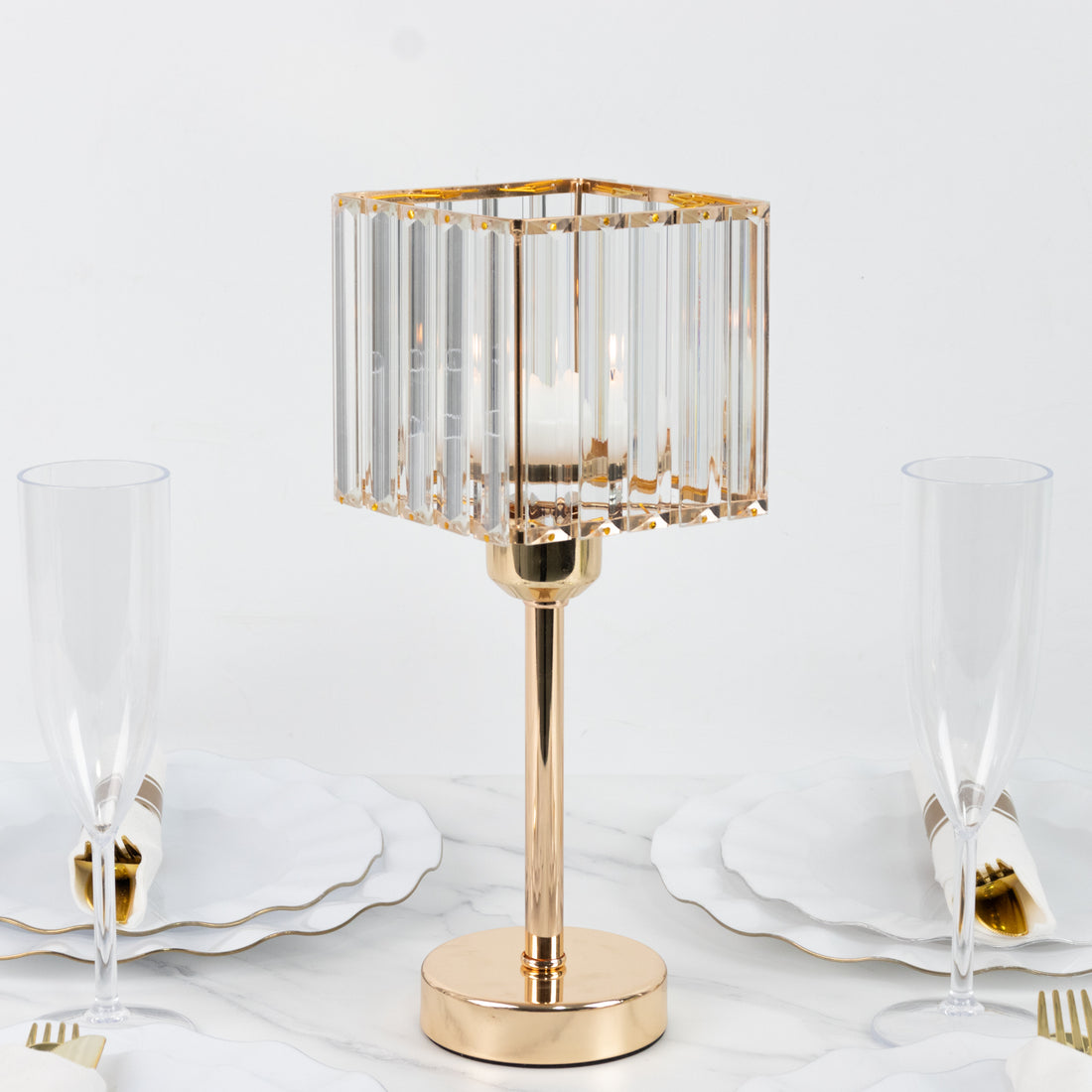 Elegant glass table lamp with gold base, surrounded by dinnerware.