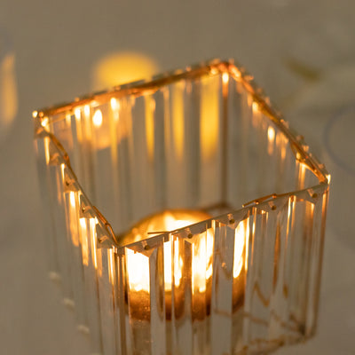 Elegant glass candle holder with warm candlelight glow.