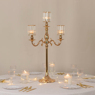 Elegant gold candelabra with glass shades on a table setting.