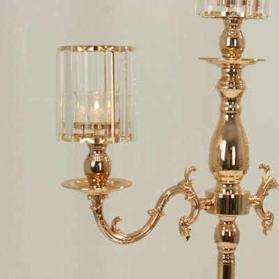 Elegant gold chandelier with glass shades and candle holders.