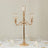 Elegant gold candelabra with crystal holders on a table setting.