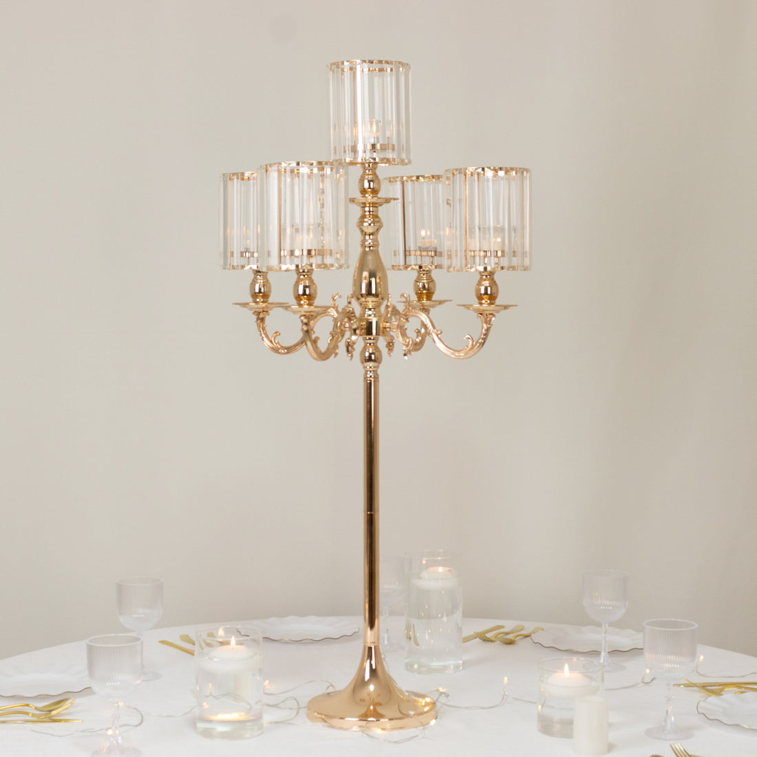 Elegant gold candelabra with glass shades, perfect for table decor.