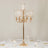 Elegant gold candelabra with glass shades, perfect for table decor.