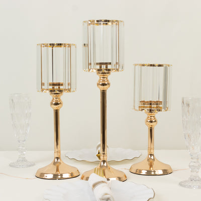 Elegant gold and crystal candle holders in varying heights for stylish decor.