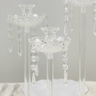 Elegant crystal candle holders with dangling prisms for home decor.
