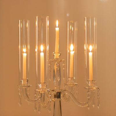 Elegant crystal candelabra with five lit candles.
