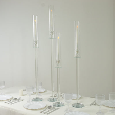 Elegant glass candle holders in varying heights with lit candles