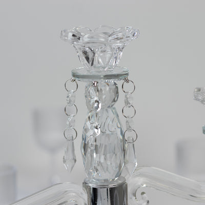 Crystal chandelier detail with elegant floral design and hanging accents.
