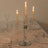 Elegant crystal candle holder with three lit candles on a dining table.