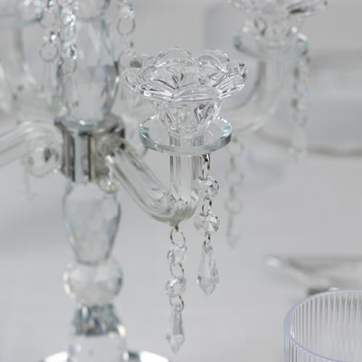 Crystal candle holder with floral design and hanging accents.