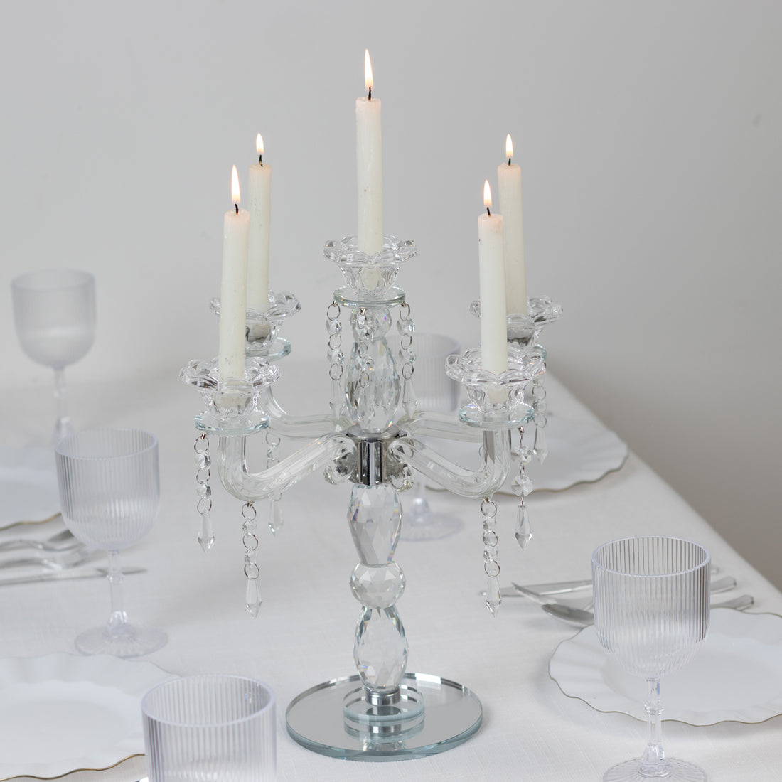 Elegant crystal candelabra with five candles on a dining table.